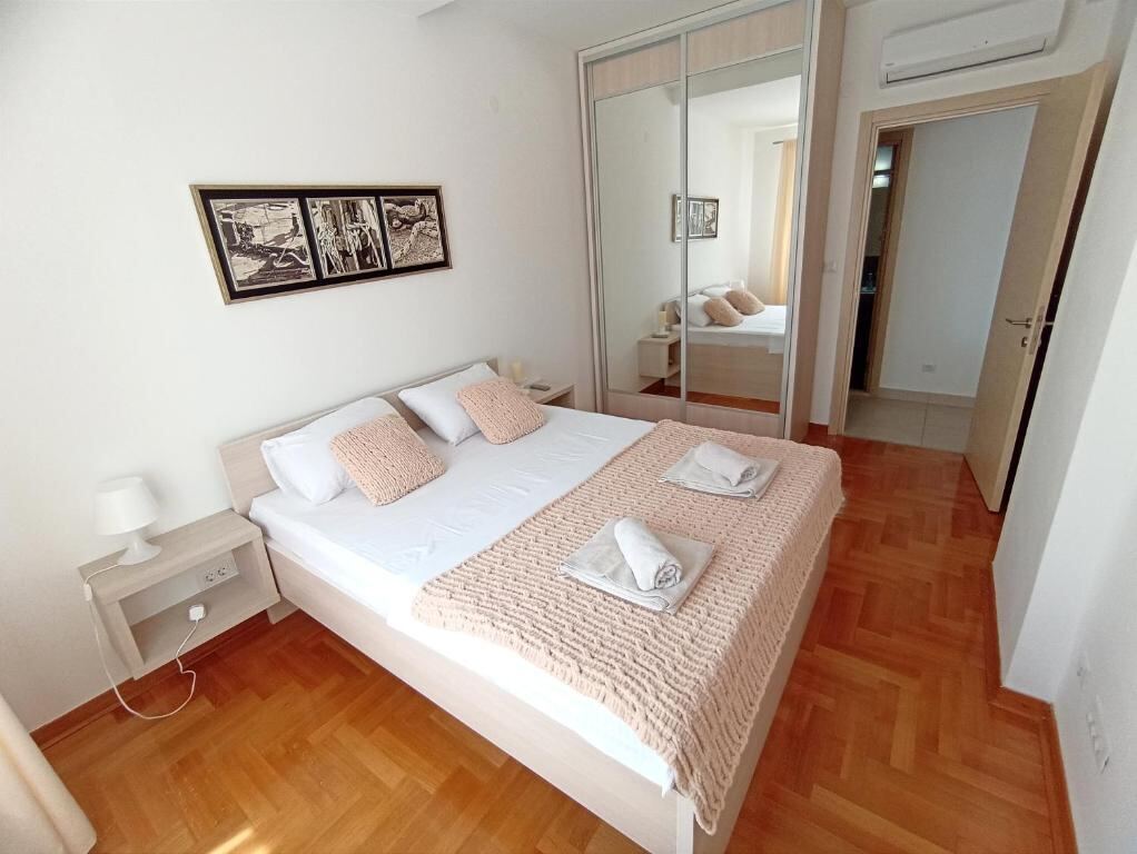 Bedroom with mirrored wardrobe and parquet floor